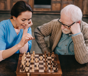 Nurse and senior man playing chess